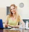 Positive woman counting the cost of medications at home