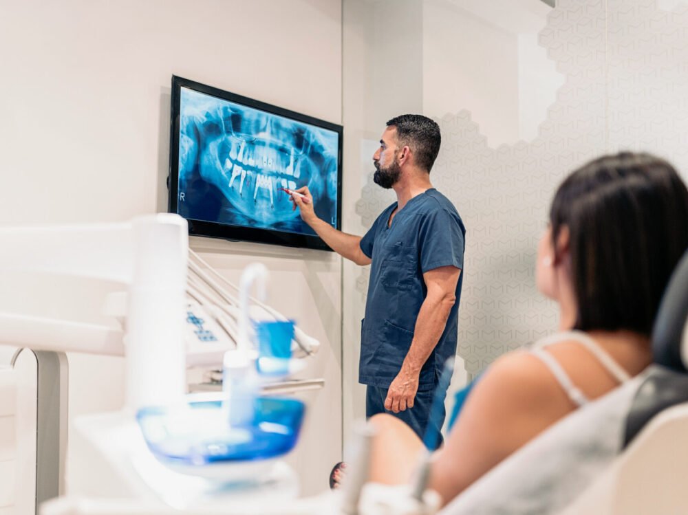 dental-clinic-worker-showing-x-ray-2023-11-27-05-23-40-utc-1 dental-clinic-worker-showing-x-ray-2023-11-27-05-23-40-utc-1